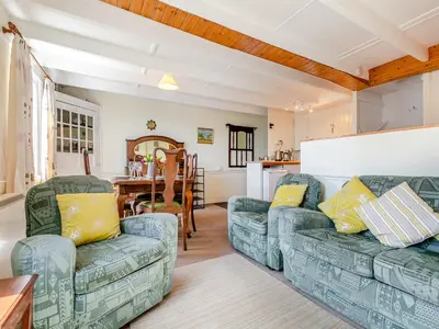a living room with two couches and a table at Memory Cottage in Mevagissey