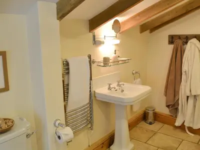 a bathroom with a sink and a toilet at The Old Wash House in Pentewan