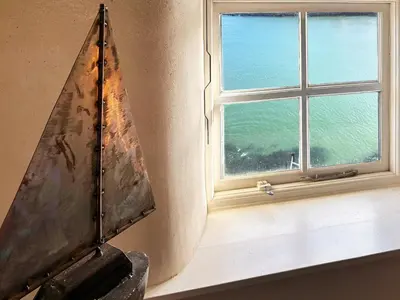 a window with a view of the ocean at Puffin Burrow in Portmellon