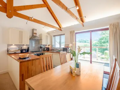 a kitchen with a wooden table and a large window at Villa Gallery- 27073 in Perranwell