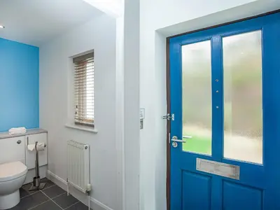 a bathroom with a blue door and a toilet at Villa Gallery - 27074 in Perranwell