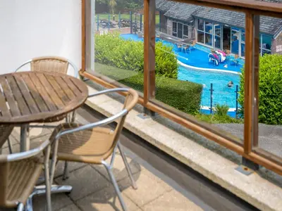 a patio with a table and chairs and a swimming pool at Villa Gallery-76 in Perranwell