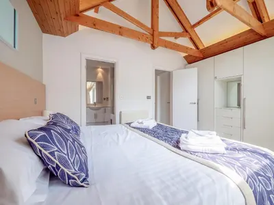 a bedroom with a large bed with blue and white pillows at Haven -78 in Perranwell