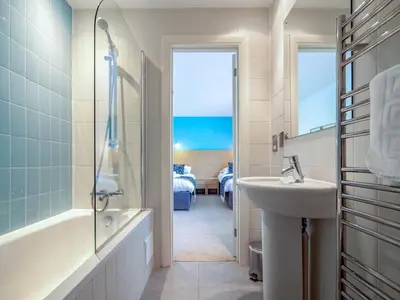 a bathroom with a tub and a sink and a shower at Haven -79 in Perranwell