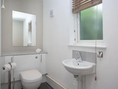 a white bathroom with a toilet and a sink at Haven -80 in Perranwell