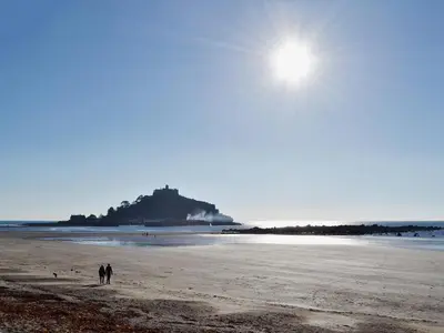 a couple of people walking on the beach at Wheal Metal Lodge in Carleen