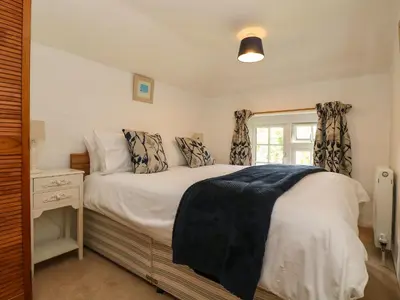 a bedroom with a bed and a window at Byre in Camelford