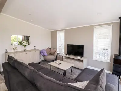 a living room with a couch and a tv at 63 The Maples in St Austell