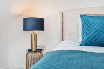 a bedroom with a blue bed and a lamp at NEW! Stunning 2 Bed Beach Front Penthouse Apartment - Topaz, Compass Point in Carbis Bay