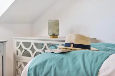 a hat is sitting on top of a bed at NEW! Stunning 2 Bed Beach Front Penthouse Apartment - Topaz, Compass Point in Carbis Bay
