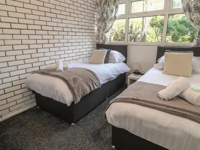 two beds in a bedroom with a brick wall at 16 Seaspray in Truro