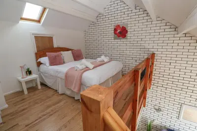 a bedroom with a bed in a brick wall at 16 Seaspray in Truro