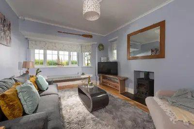 a living room with a couch and a fireplace at Mermaid Cottage, Carbis Bay in Carbis Bay