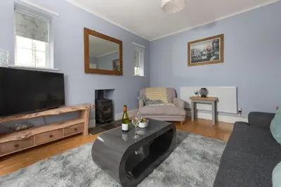 a living room with a large flat screen tv at Mermaid Cottage, Carbis Bay in Carbis Bay
