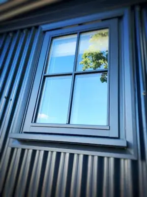 a window on a building with a tree in it at Cornwall Woodland Shepherd's Hut - Dennis Hut in Bodmin