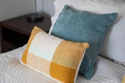 two pillows sitting on a bed with a table at The Rum House in Helston
