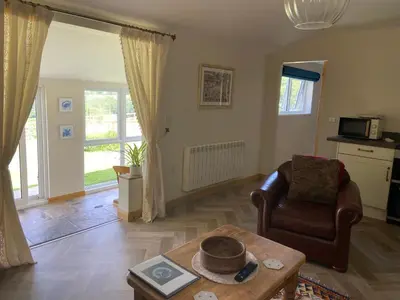 a living room with a chair and a coffee table at Moorland Breeze in Blisland