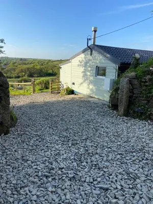 a gravel driveway in front of a white building at Moorland Breeze in Blisland