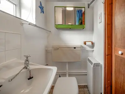 a bathroom with a tub and a toilet and a sink at Holiday Home The Homestead by Interhome in Gorran Haven