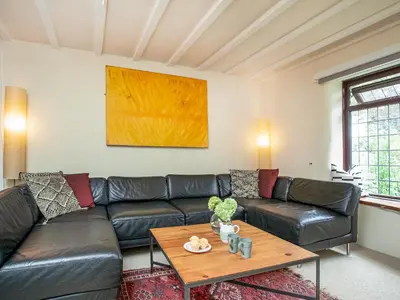 a living room with a leather couch and a table at The Nook in Saint Ewe