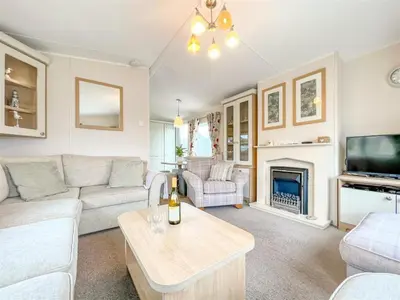 a living room with a couch and a tv at Pottsville Cabin Sleeps 4 with Deck in Praa Sands