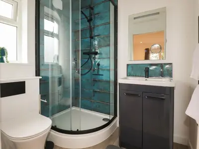 a bathroom with a shower and a toilet and a sink at Pheasant View in Truro