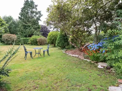 two chairs and a table in a garden at Pheasant View in Truro