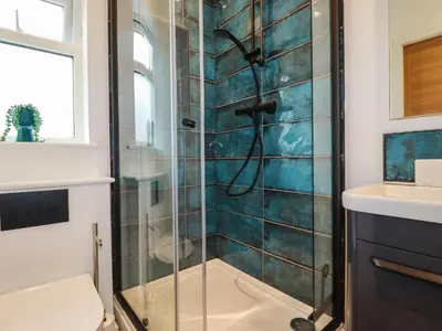a bathroom with a shower with a glass door at Pheasant View in Truro