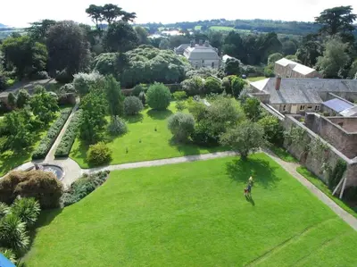 an aerial view of a park with a person standing in the grass at The Coach House within heritage Tregrehan Garden on Cornwall's South Coast in Carlyon Bay