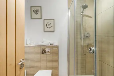 a bathroom with a shower with a glass door at The Hawthorns in Polzeath