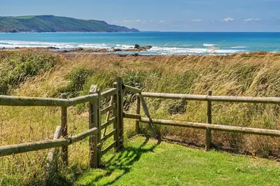 a wooden fence on the side of a beach at Finest Retreats - Driftwood in Poundstock