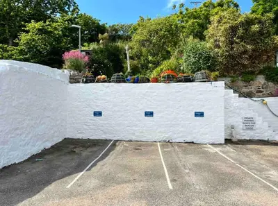 a white fence with flowers on top of it at Luxury Modern Suite in Marazion with Parking in Marazion