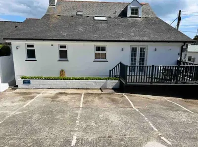 a white house with a parking lot in front of it at Luxury Modern Suite in Marazion with Parking in Marazion