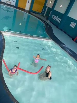 a man and two children swimming in a swimming pool at Gannets Rest - Spacious Static Caravan with Sea Views in Polperro