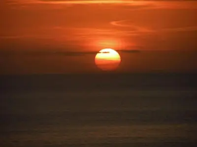 a sunset over the ocean with the sun in the sky at Hawkers Padstow in Padstow