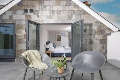 a room with two chairs and a bed at Watersend in Porth