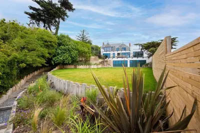 a garden with a fence and a house in the background at Watersend in Porth