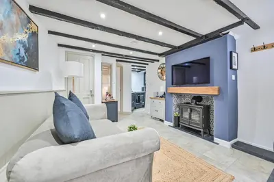 a living room with a couch and a fireplace at Luxury Couple's Getaway with River Views and Parking in Polperro