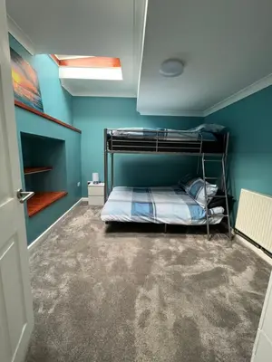 a bedroom with a bunk bed and blue walls at Pet friendly cottage in Pool