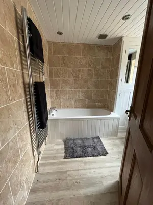 a bathroom with a bath tub and a rug at Pet friendly cottage in Pool