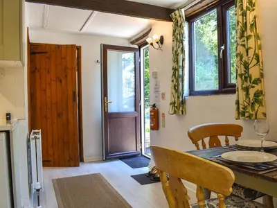 a dining room with a table and chairs and a door at Tarow Cottage in Morval