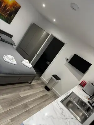 a small bedroom with a bed and a sink at The Cosy Nook in Redruth
