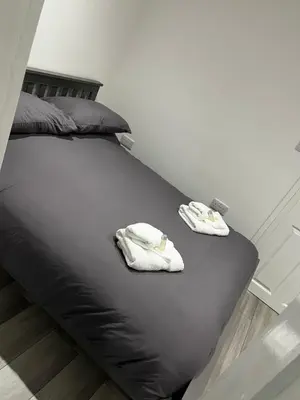 two towels are sitting on a black bed at The Cosy Nook in Redruth