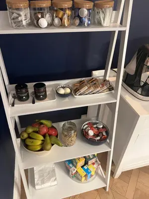 a white shelf filled with lots of fruits and vegetables at The Captain's House in Looe