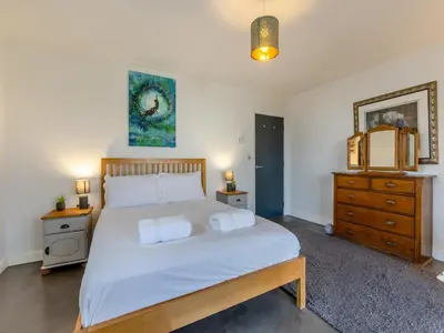 a bedroom with a large bed and two night stands at Tregarden in Bude