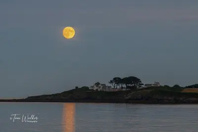 a full moon rising over a body of water at An Mordros 15 Polkirt Heights in Mevagissey