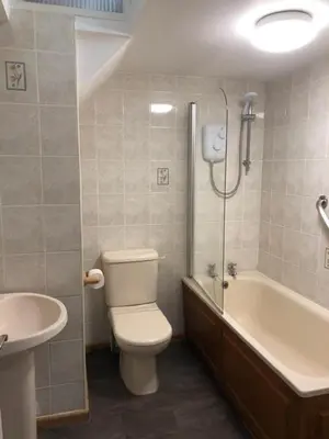 a bathroom with a toilet and a tub and a sink at 3Bed Apartment Sleeps 5- Parking Wifi Near Beach in Looe