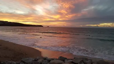 a group of people in the water at the beach at The Pigsty & Spa Garden at Tregoose Old Mill in Newquay