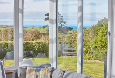 a living room with large windows and a couch at Little Seawynds in Port Isaac