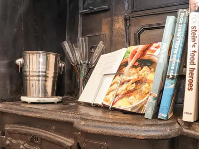 a table with a book and a pot and books at Little Polgray in St Austell